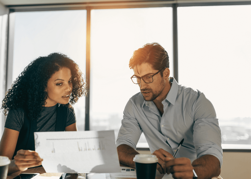 a man and woman looking at a piece of paper