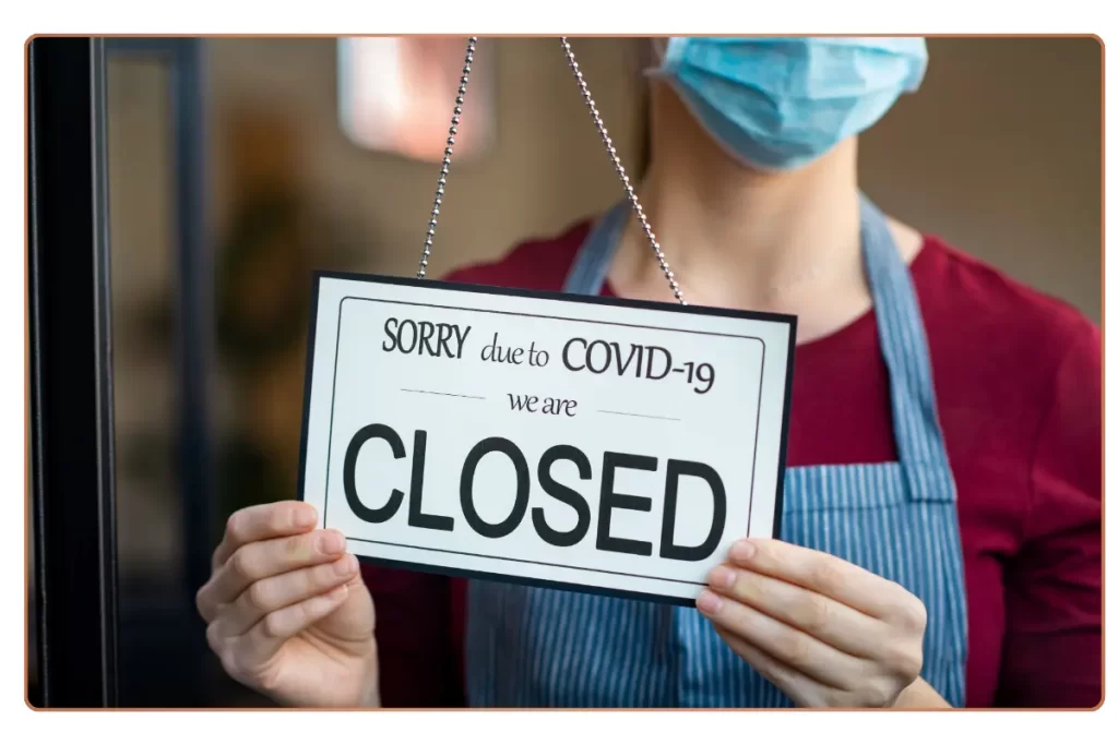 A woman showing closed signboard due to covid-19