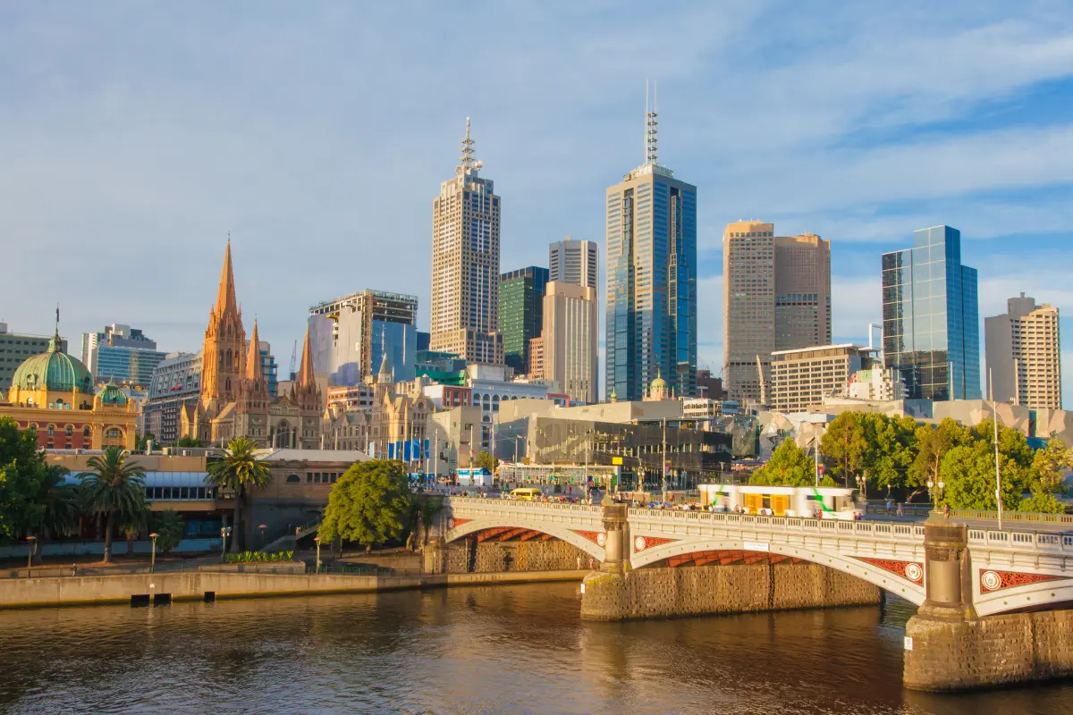 a bridge over a river with a city in the background