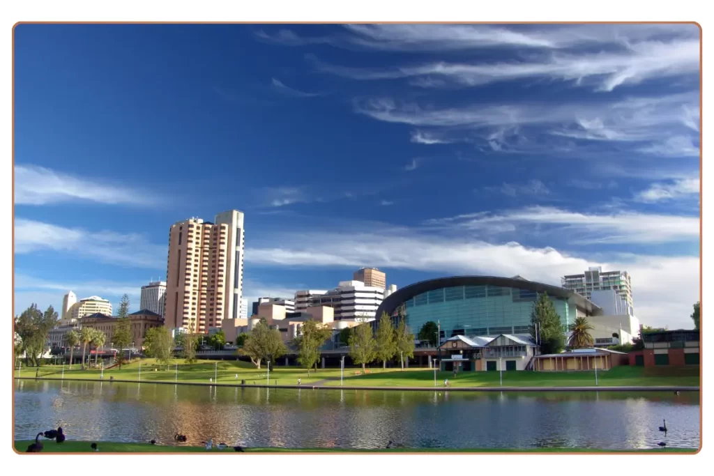 a city skyline with a lake and grass