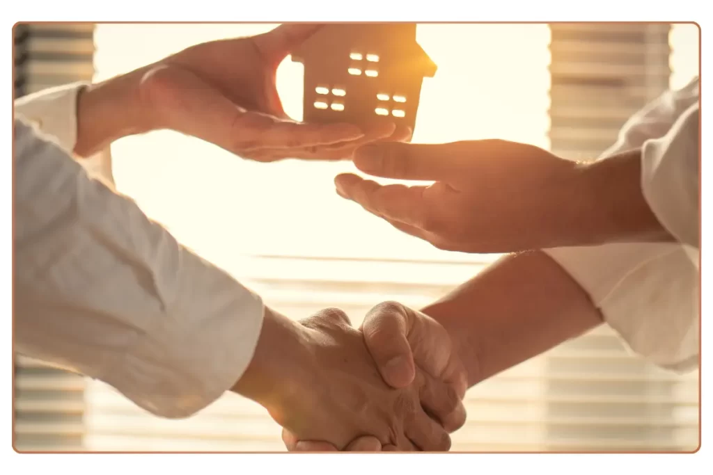 a hands shaking hands with a house model