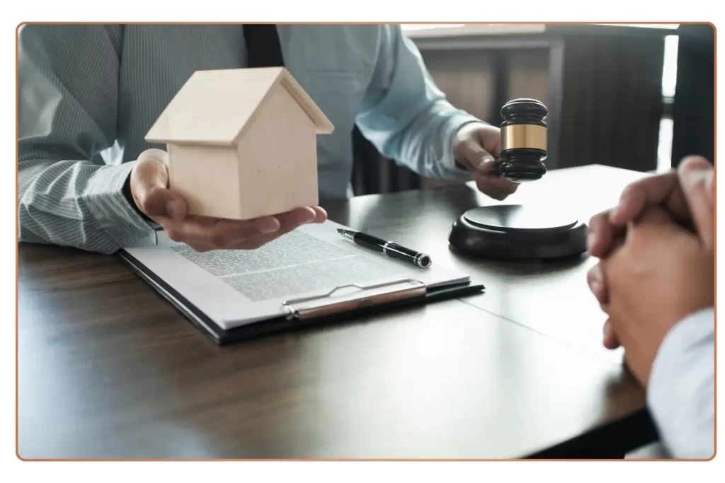 a person holding a small house and a gavel