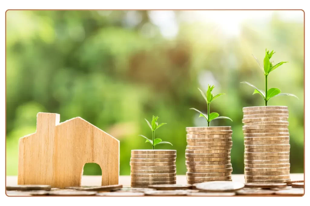 a stack of coins with a small house and a small plant growing on them